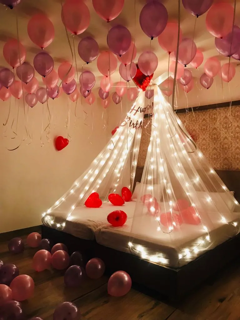 Romantic room decoration with fairy lights and rose petals