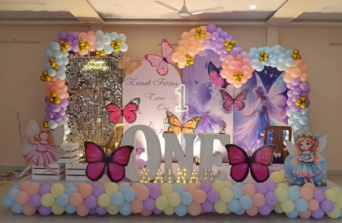 Fairy Theme with balloons, 1 cake table, neon light, LED name & age, 2 Fairy Cutouts, balloon arch and lights.